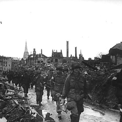 Soldaten marschieren durch die Ruinen von Münster. 