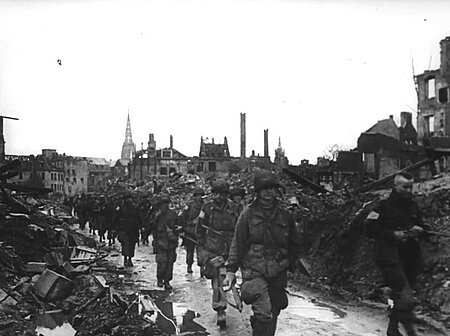 Soldaten marschieren durch die Ruinen von Münster. 