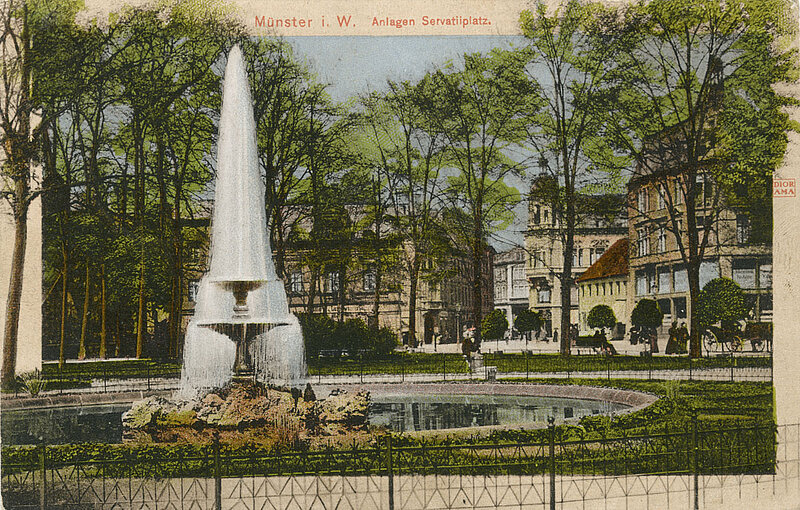 Postkarte, coloriertes Schwarzweißbild. Springbrunnen mit Parkanlage vor Häuserfassaden.