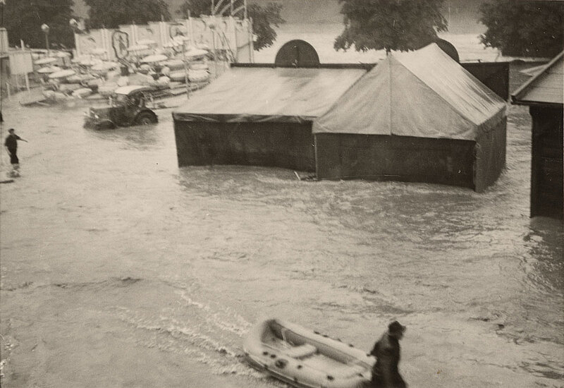 Schwarzweißbild: Die Schießhalle Schönhagen-Genert, bestehend aus zwei Zelten, von hinten. Umspült von einem Hochwasser.